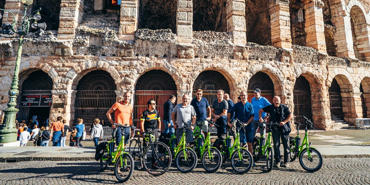 by e-bike in front of Arena of Verona